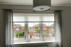 Braided semi sheer roller blind with coloured voile dress curtains and brushed stainless steel pole