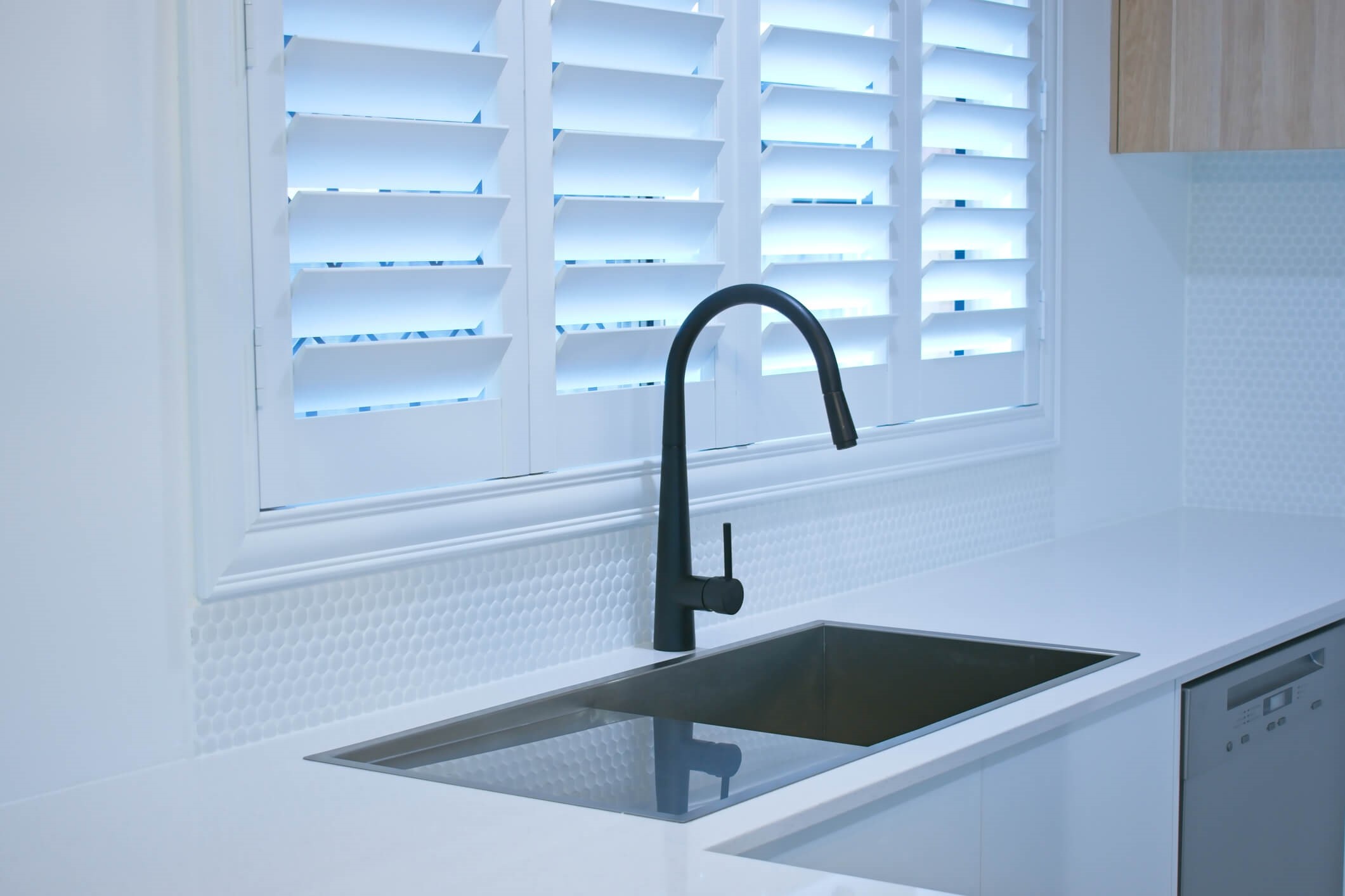 white window shutters with black tap in kitchen