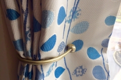 Close up Burnished brass curtain holdback