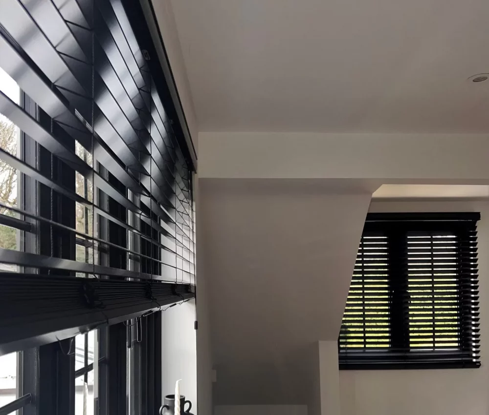Wood Venetian blinds with 50mm wide slats in a black painted finish. Installed in a Modern living room in Hatfield