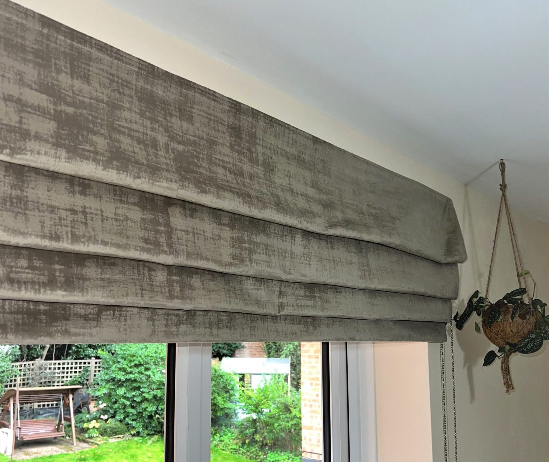 Elegant textured Roman blind in taupe velvet fabric installed in a Welwyn Garden City home.