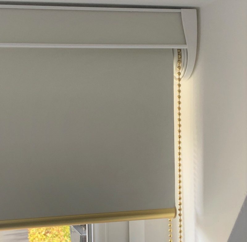 Fascia roller blind in blockout fabric, with brass chain control and brass round bottom bar, installed in Welwyn Garden City