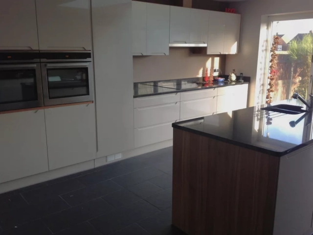 Modern Handleless Kitchen. Minimal kitchen design. Sink installed in kitchen island.