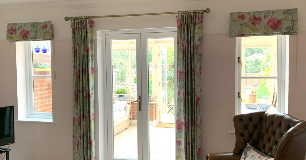 Roman blinds and pinch pleat curtains on brass pole with decorative finials