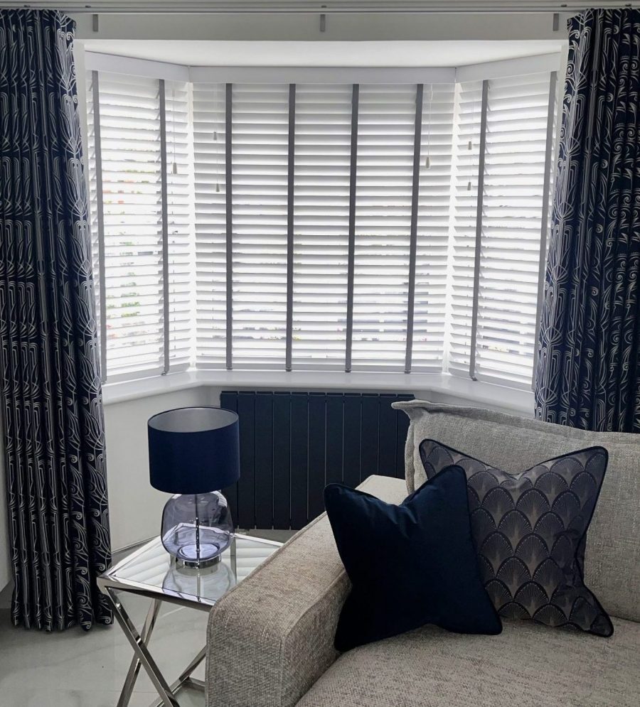 Wood venetian blinds with ladder tapes in contrasting colour. Wave curtains in Navy Art Deco fabric on a Silent Gliss Metropole track
