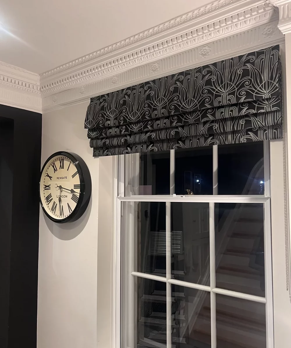 Roman blind in black art deco embroidered fabric fitted in the hallway of a period property in Hertford