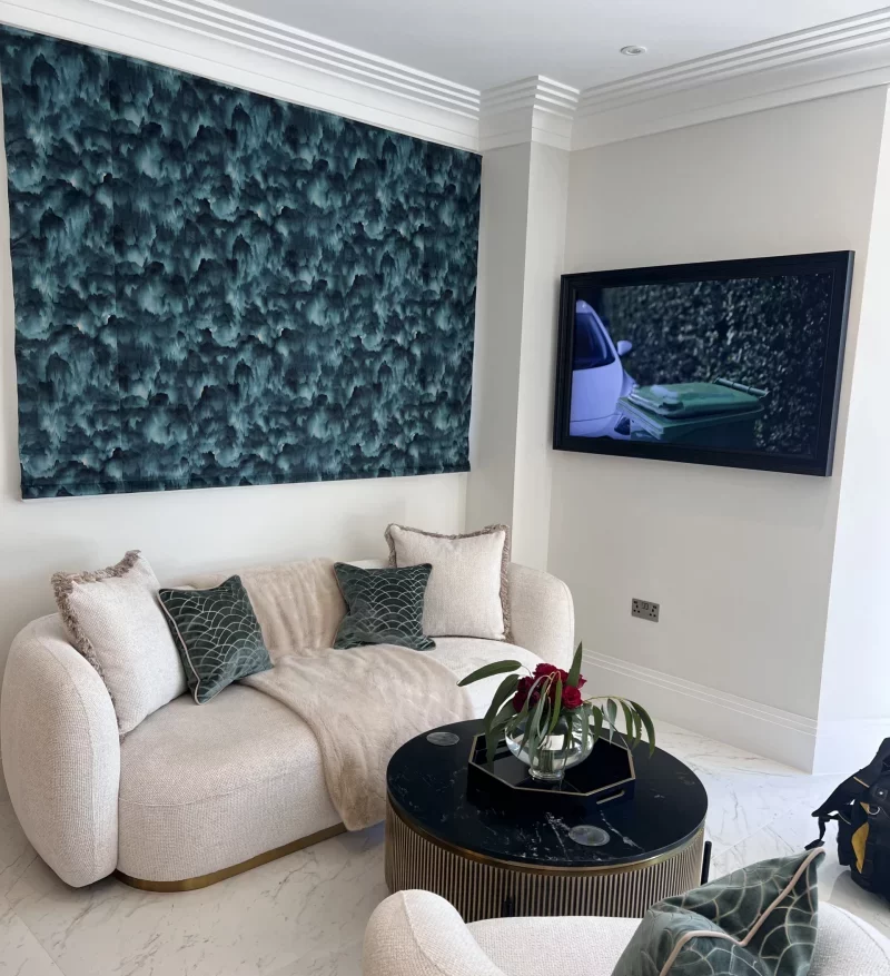 Motorised roman blind in an emerald green patterned velvet fabric, installed in a Stevenageliving room