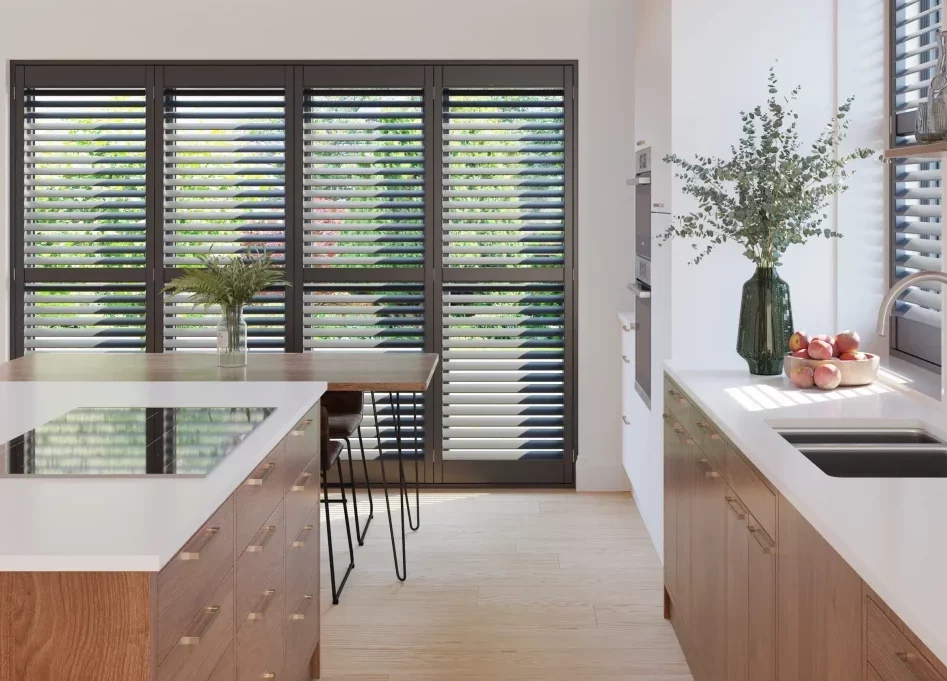 Full height painted hardwood shutters with midrails installed in a modern open plan kitchen