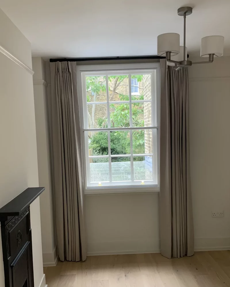Double Pinch pleat curtains on a black tracked pole in a London rental property
