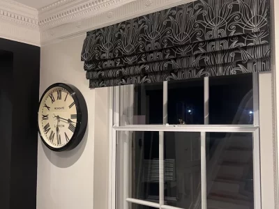 Roman blind in black art deco embroidered fabric fitted in the hallway of a period property in Hertford